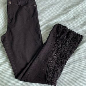 Simon Chang black jeans with a bedazzled leg
